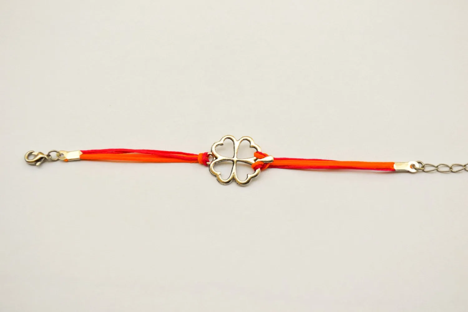 Clover bracelet, orange and pink cord bracelet with a silver shamrock charm, children's size